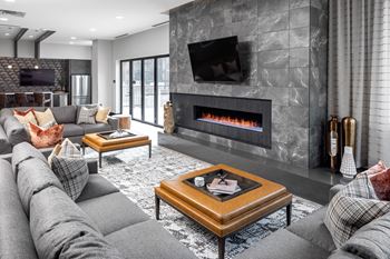 A living room with a gray couch and a fireplace